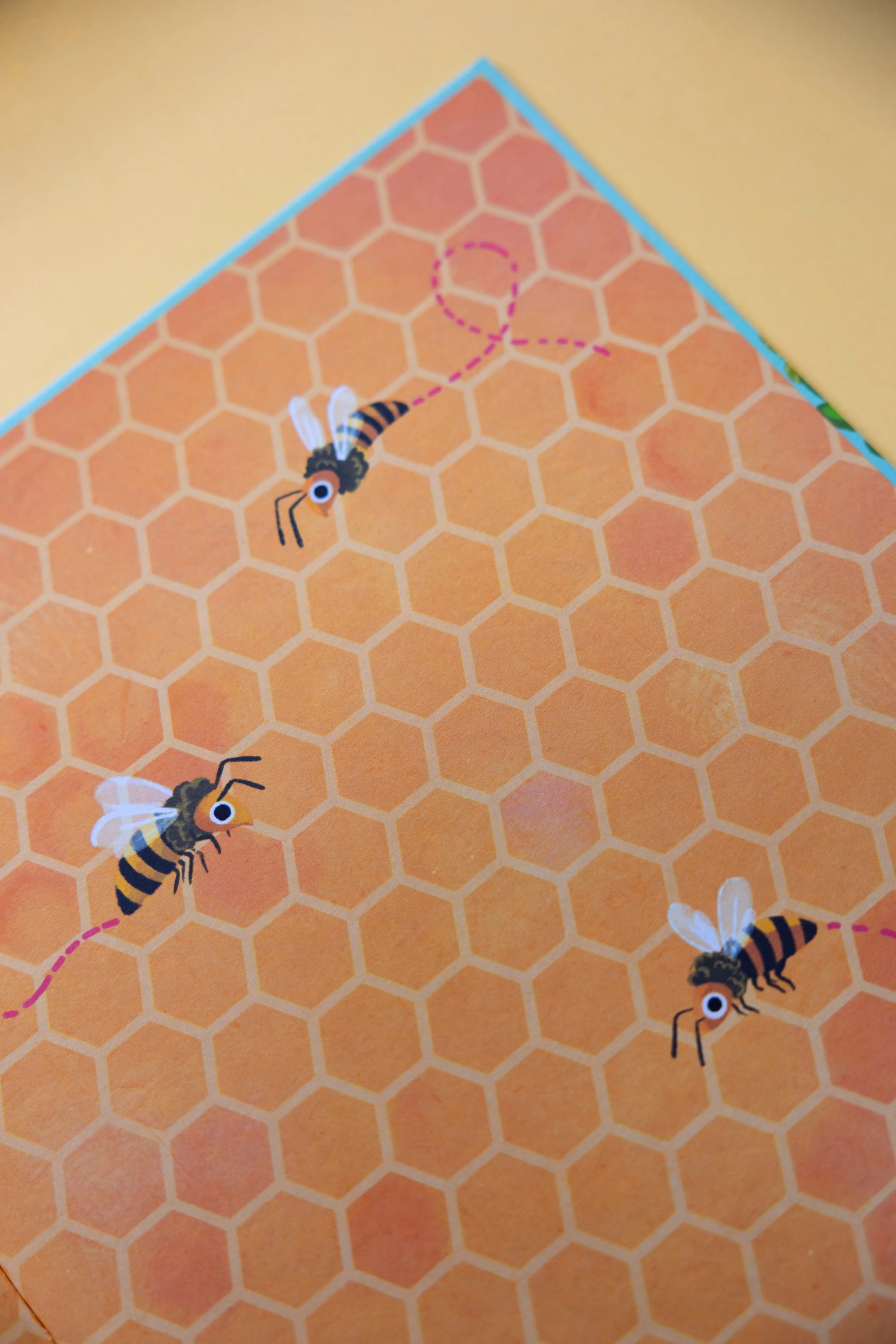 Illustration of bees with honeycomb background and pink dashed flight paths.