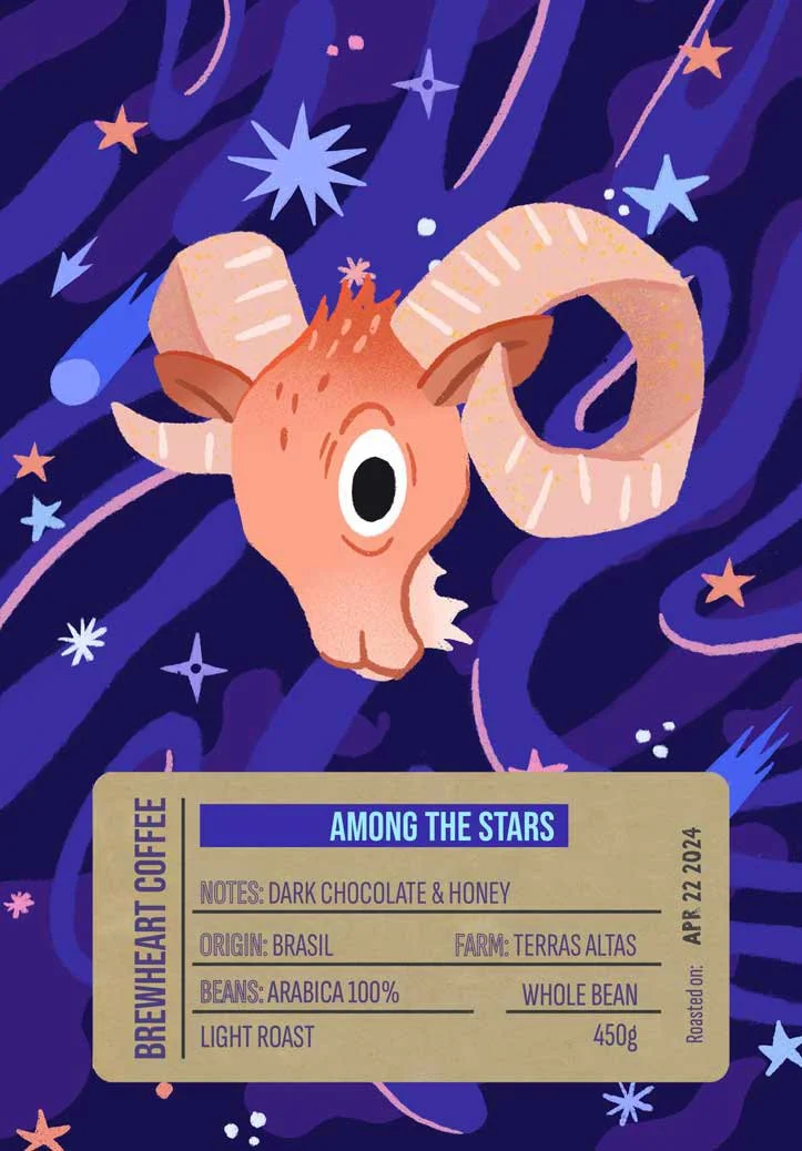A cartoon illustration of a goat with large curved horns floating among stars and cosmic elements in a dark purple and blue space background, with a gold coffee label at the bottom.