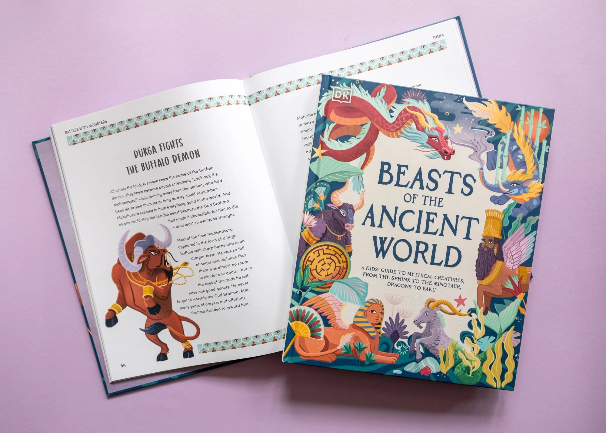 Open book titled 'Beasts of the Ancient World' with colorful illustrations of mythical creatures and a purple background, placed on a pink surface.