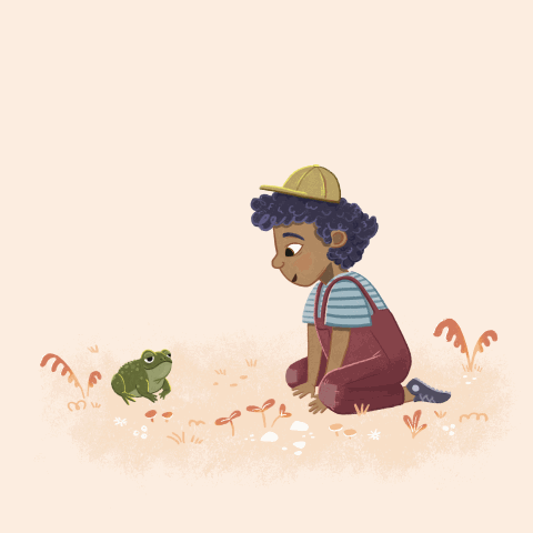 A young boy with curly hair, wearing a yellow cap, blue striped shirt, and overalls, is crouching on the ground, looking at a small green frog in a grassy area with plants and flowers.