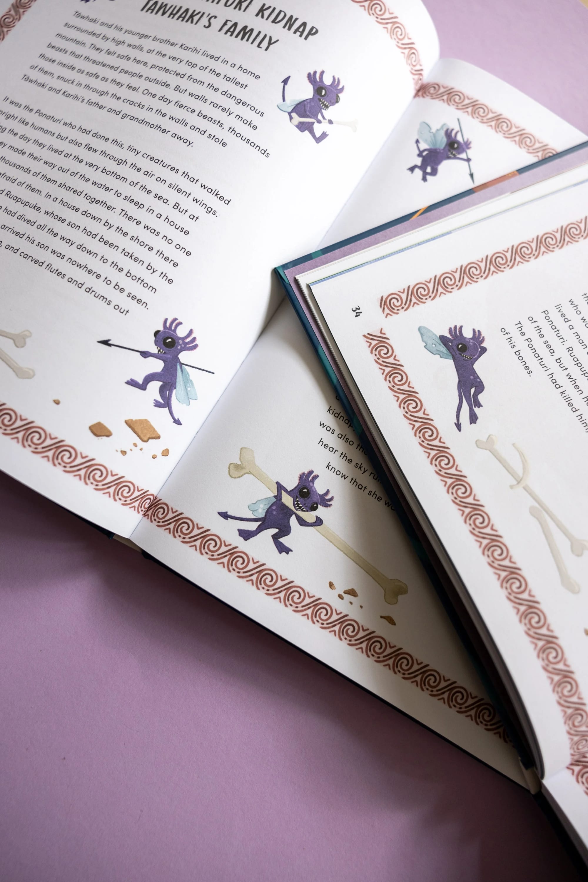 Open book with illustrations of a purple fairy-like creature with wings, holding a spear and a bone, with decorative border and text about a mythological story, on a pink background.