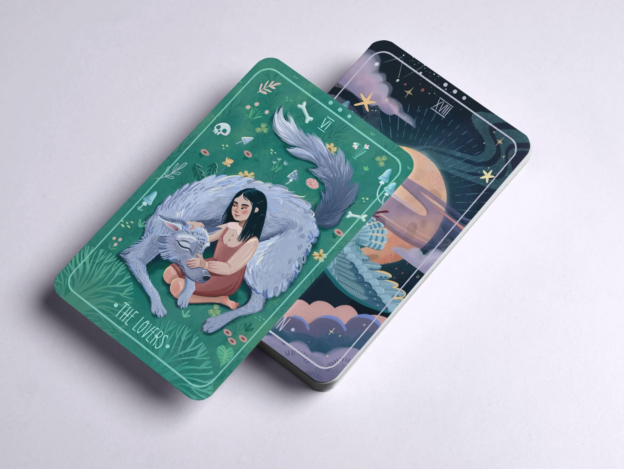 A card depicting a person with dark hair cuddling a large, gray wolf, surrounded by nature and small mystical symbols, with the words 'The Lovers' at the bottom.