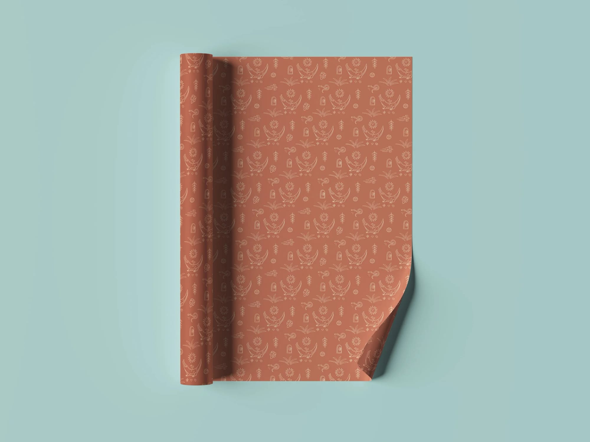 A sheet of pasture-colored paper with a camping-themed pattern, partly curled at the bottom right corner, on a light teal background.