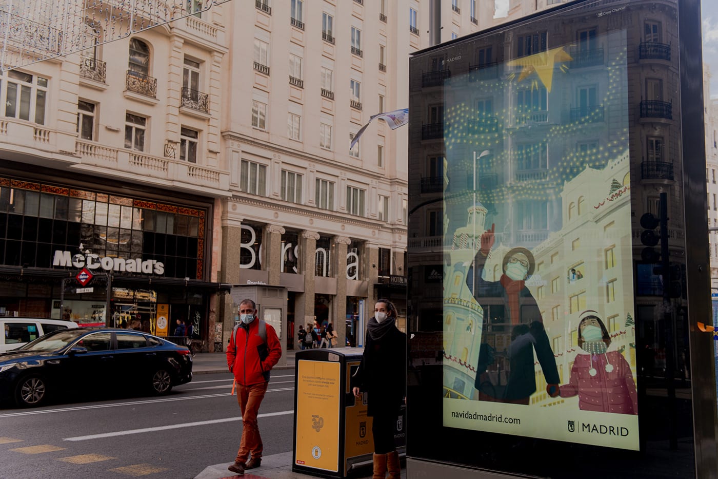 Madrid Navidad poster displayed at a bus stop on Gran Vía.